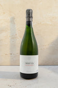 Botella de cava Wellnex Mestres Cavateca MAS VIA 1998 con etiqueta elegante sobre superficie de piedra clara