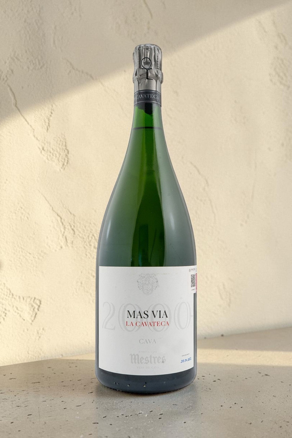 Botella Magnum de cava Mestres Cavateca 2000 Mas Via de Wellnex sobre superficie clara con iluminación natural
