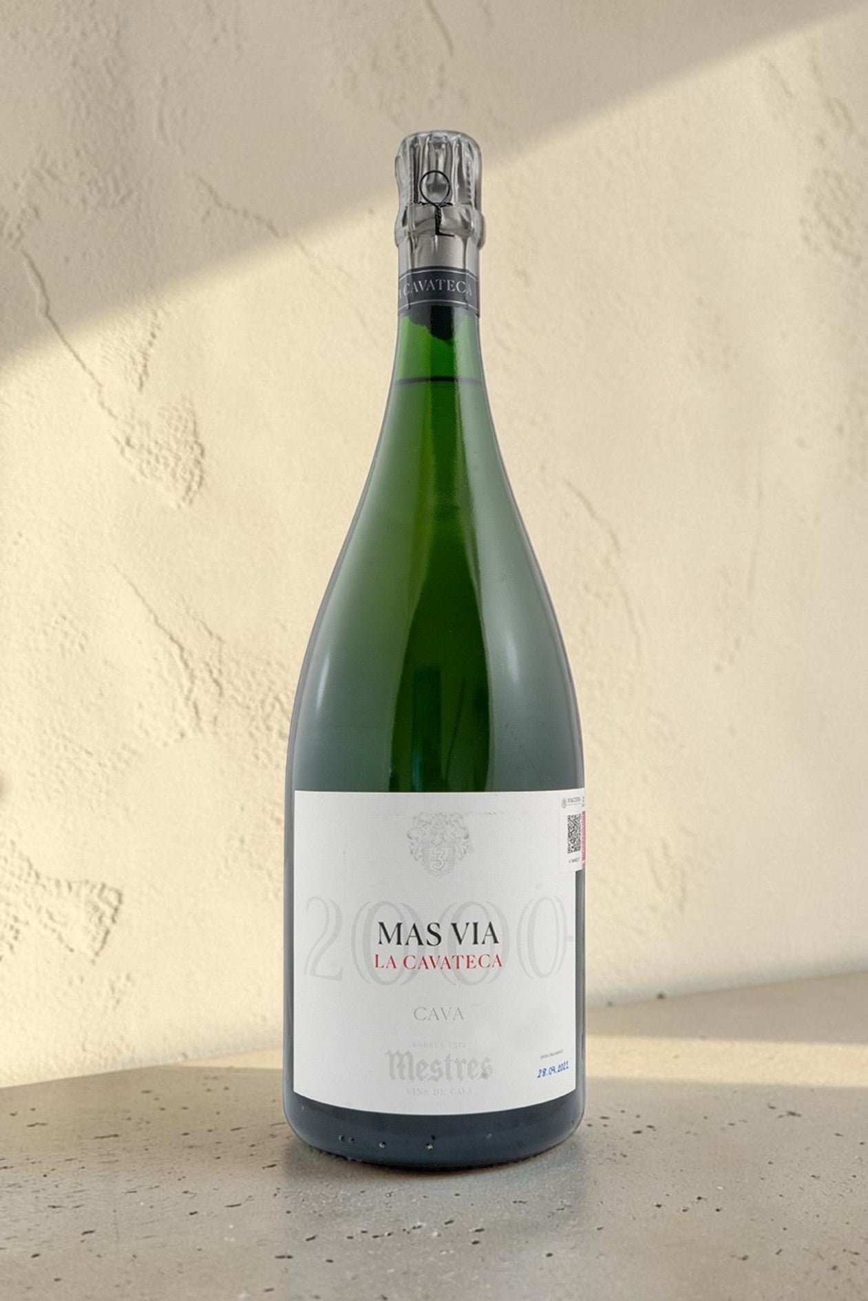 Botella Magnum de cava Mestres Cavateca 2000 Mas Via de Wellnex sobre superficie clara con iluminación natural