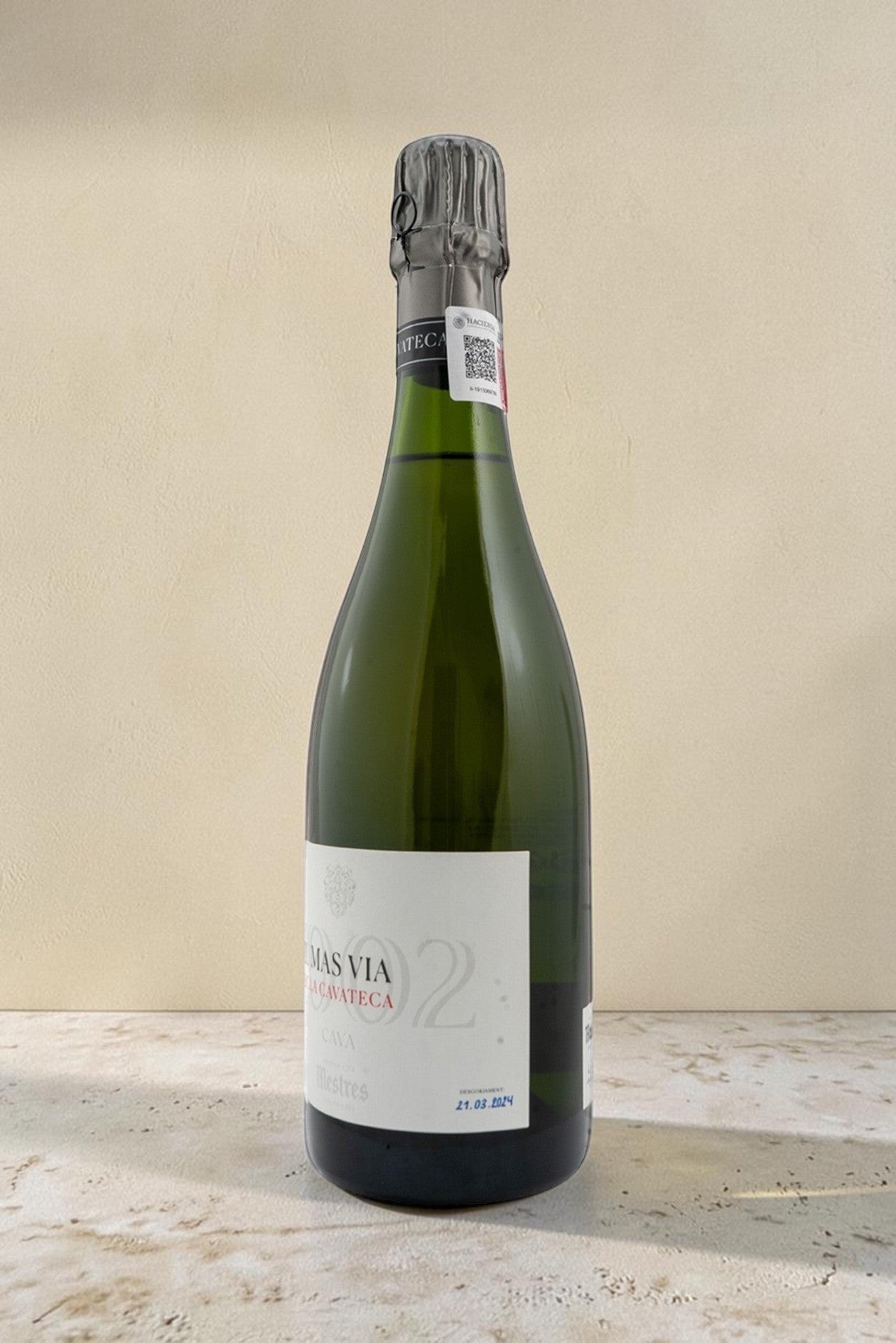 Botella de cava Mestres Cavateca MAS VIA 2002 de Wellnex sobre una superficie clara con iluminación natural