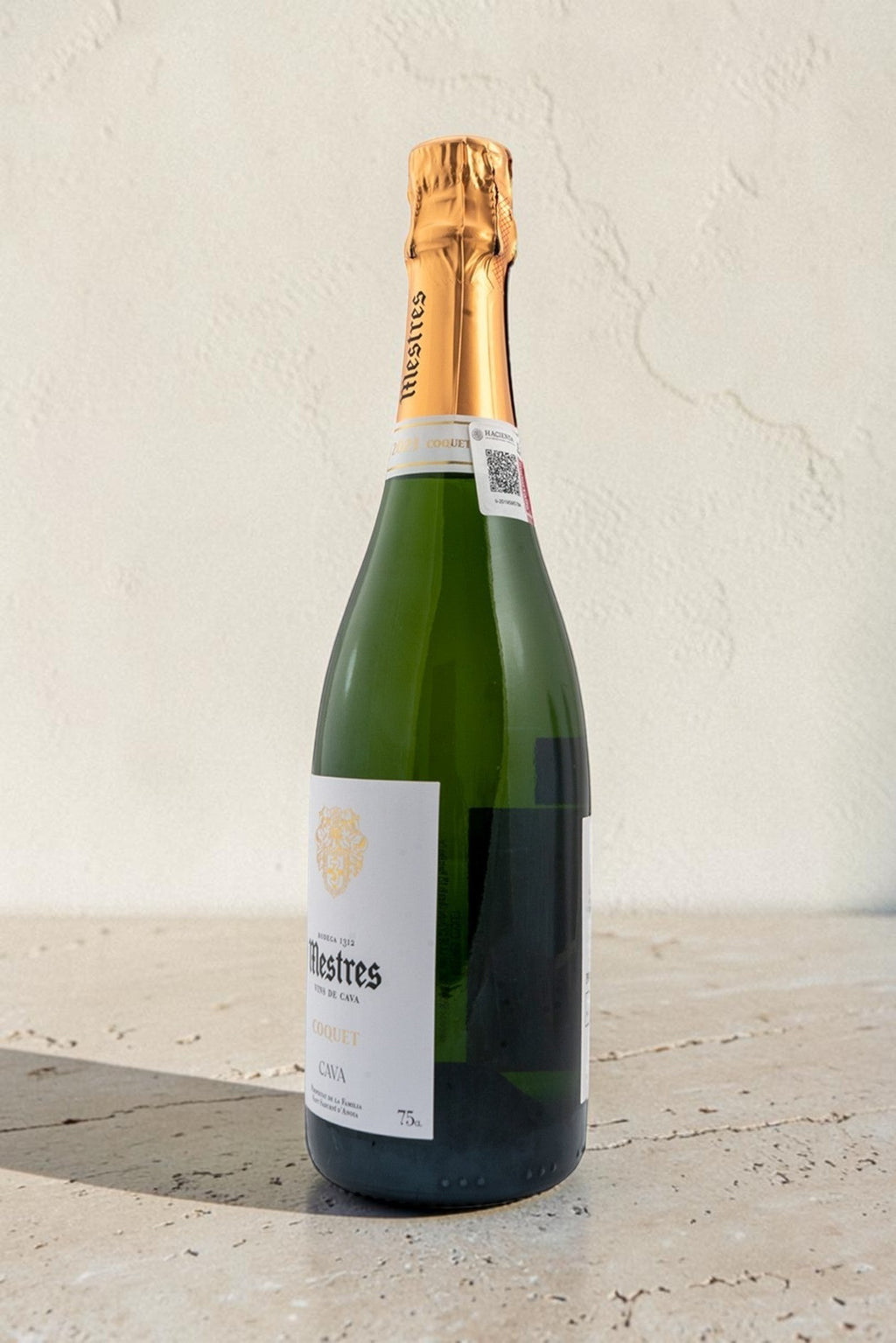Botella de cava Mestres Coquet de Wellnex con etiqueta elegante y cápsula dorada sobre superficie clara