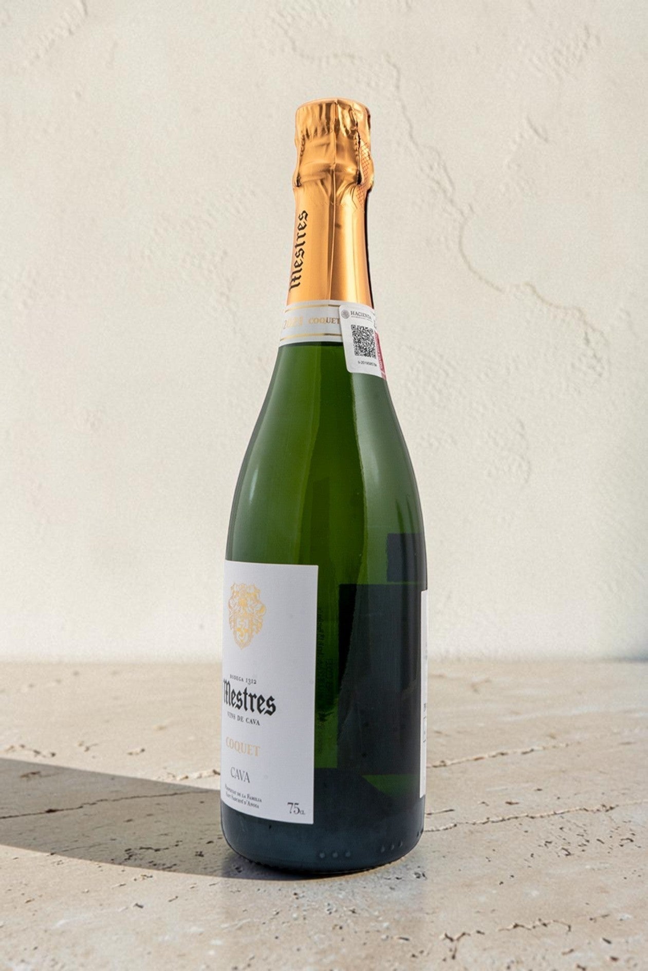 Botella de cava Mestres Coquet de Wellnex con etiqueta elegante y cápsula dorada sobre superficie clara