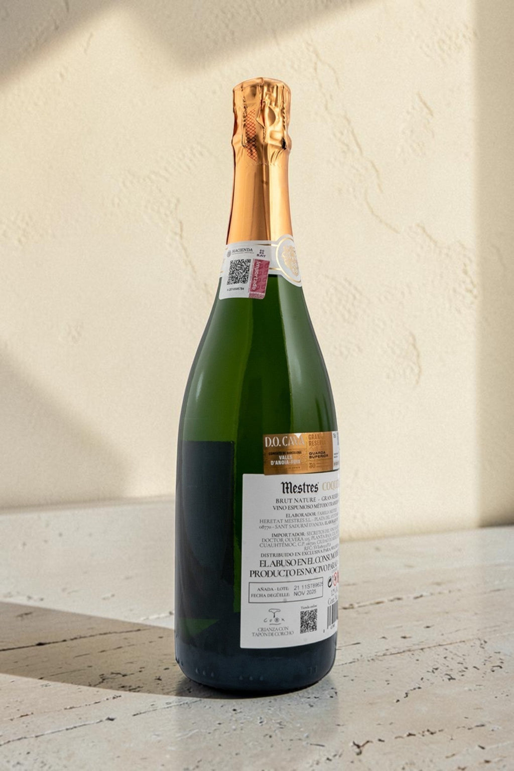 Botella de cava Mestres Coquet de Wellnex con etiqueta detallada y cápsula dorada sobre superficie clara