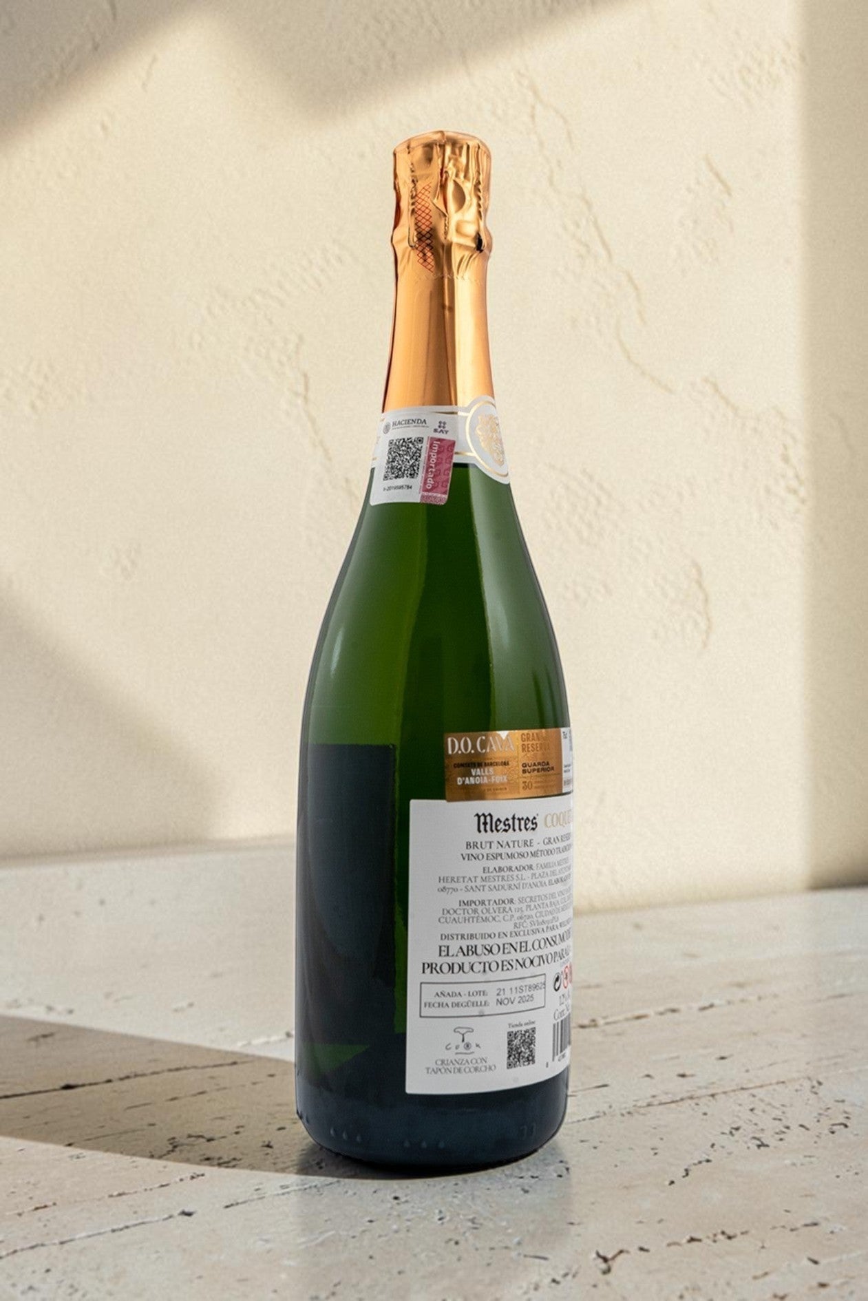 Botella de cava Mestres Coquet de Wellnex con etiqueta detallada y cápsula dorada sobre superficie clara