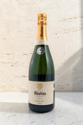 Botella de cava Wellnex Mestres Visol 2019 con etiqueta elegante y cápsula dorada sobre fondo de piedra natural