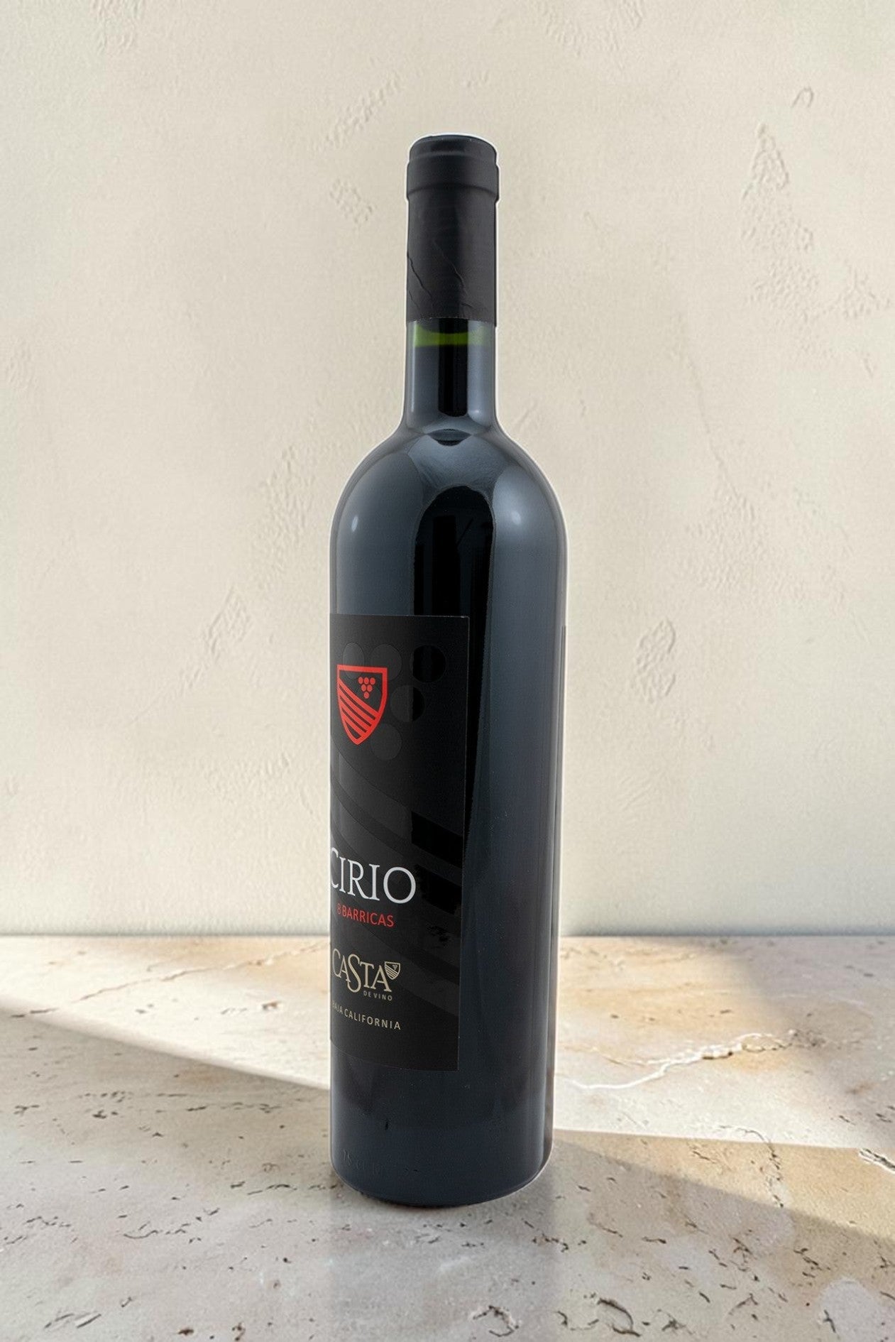 Botella de vino tinto Cirio de Wellnex con etiqueta negra, color rubí y diseño elegante sobre superficie clara.