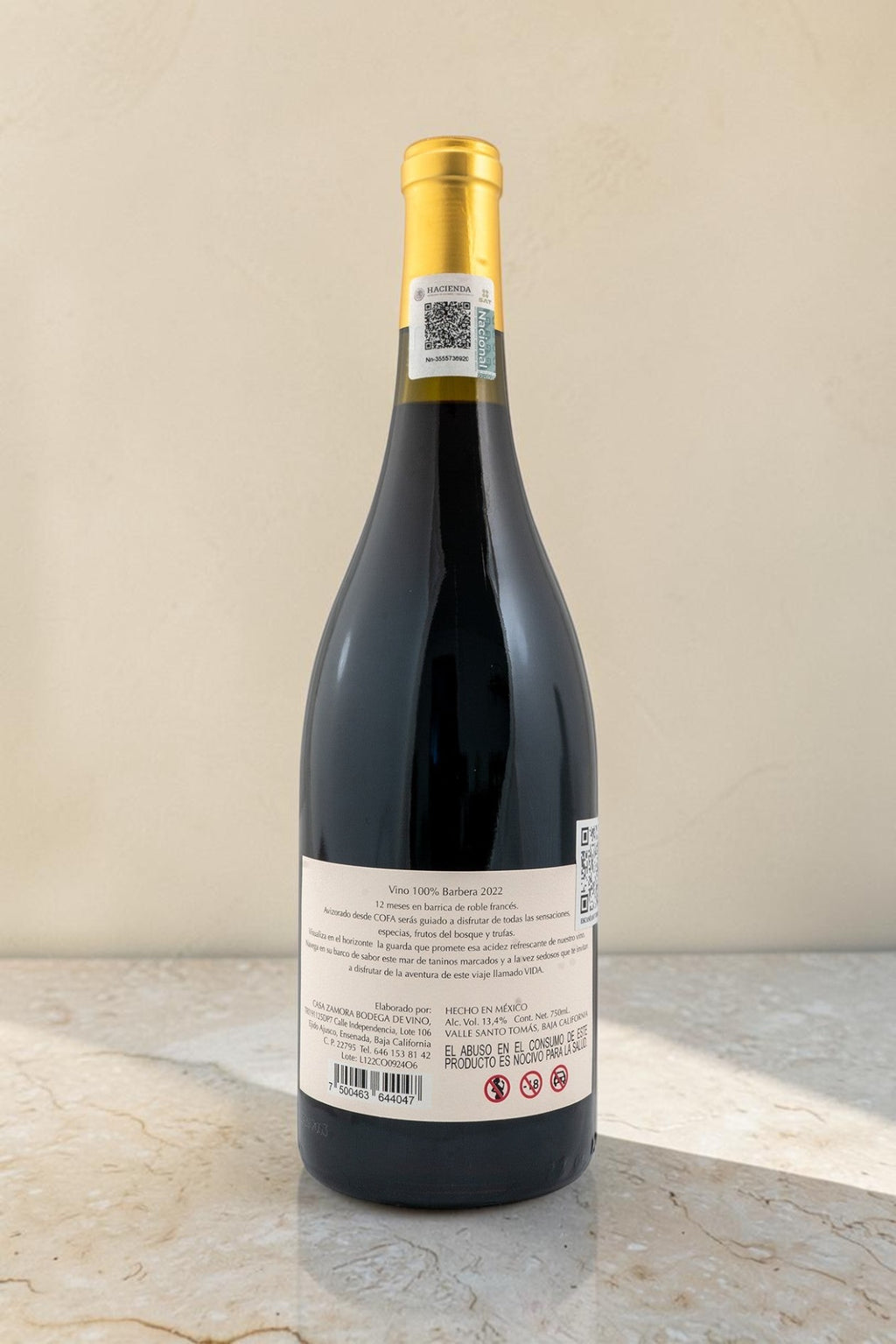 Botella de vino tinto Wellnex Cofa 2022 con etiqueta trasera detallada sobre superficie de mármol