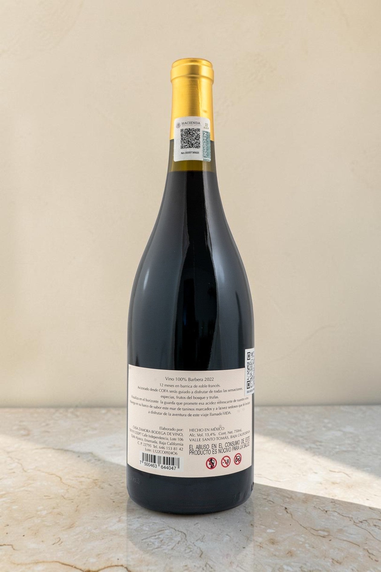 Botella de vino tinto Wellnex Cofa 2022 con etiqueta trasera detallada sobre superficie de mármol