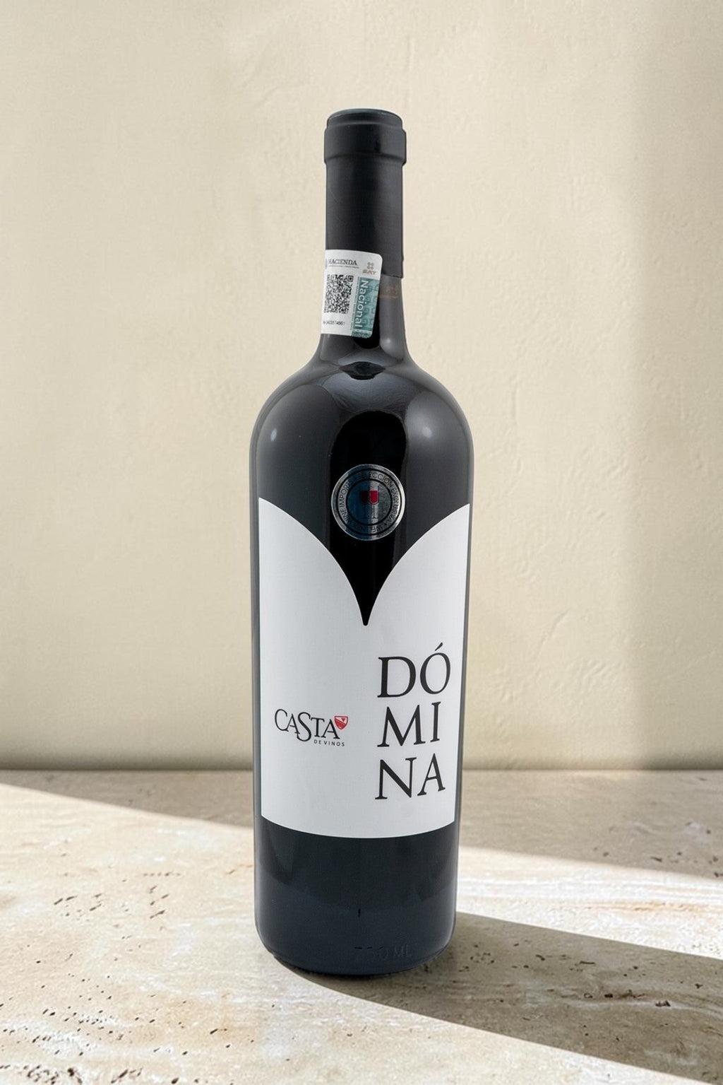 Botella de vino tinto Domina Magnum de Wellnex con etiqueta blanca minimalista sobre fondo neutro