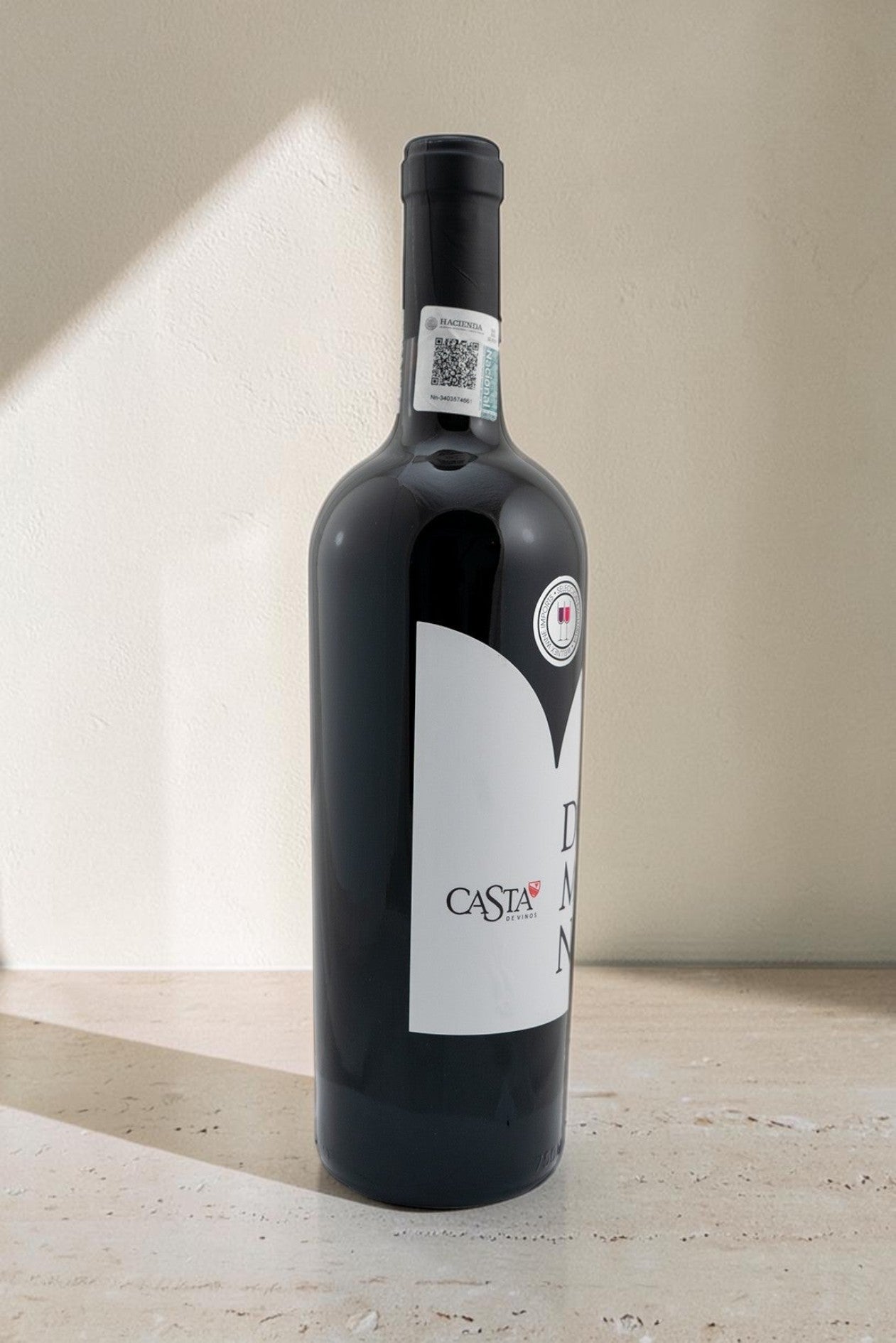 Botella de vino tinto Domina Magnum de Wellnex con etiqueta blanca minimalista sobre fondo neutro