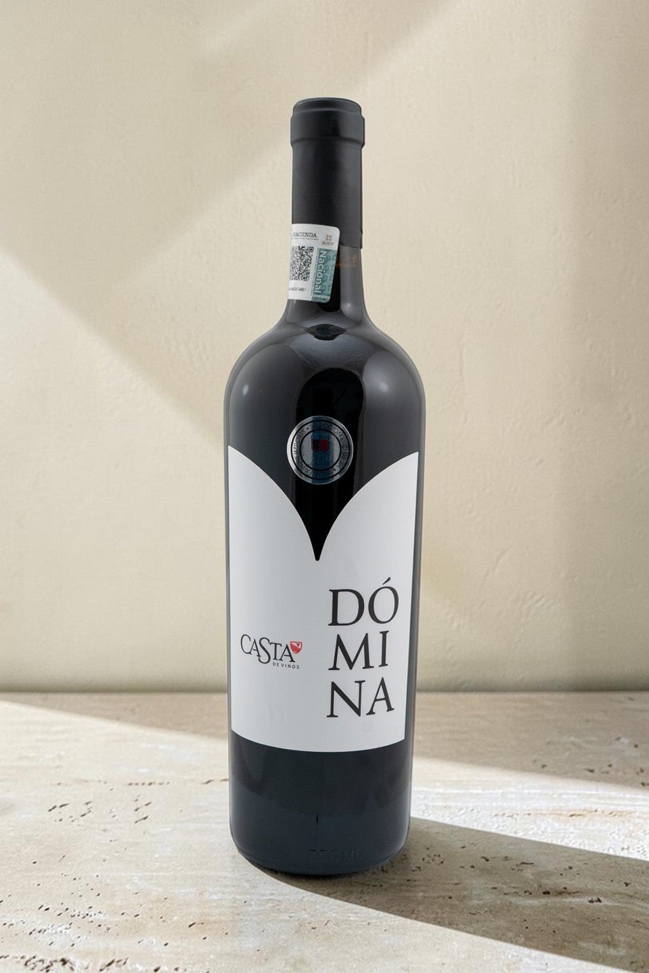 Botella de vino tinto Domina Magnum de Wellnex con etiqueta blanca sobre fondo neutro