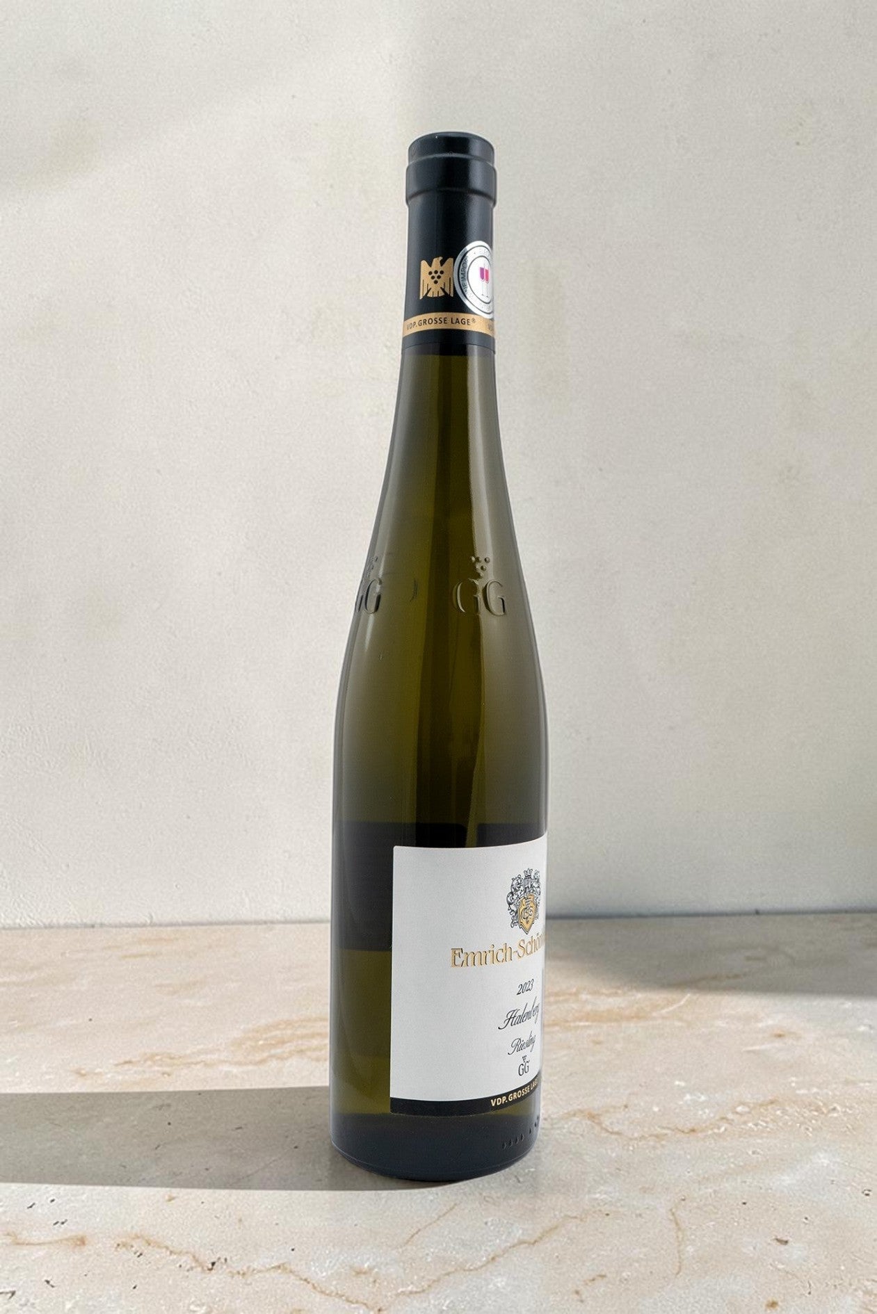Botella de vino blanco Emrich Schonleber VB Halenberg Riesling GG 2023 de Wellnex sobre superficie de piedra clara