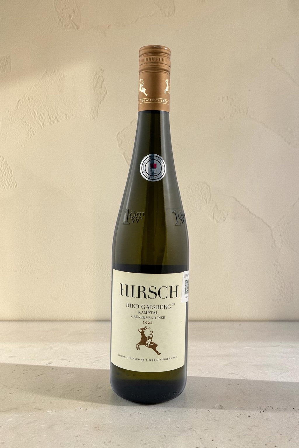 Botella de vino blanco Wellnex Hirsch Ried Gaisberg Gruner Veltliner con etiqueta elegante sobre fondo neutro