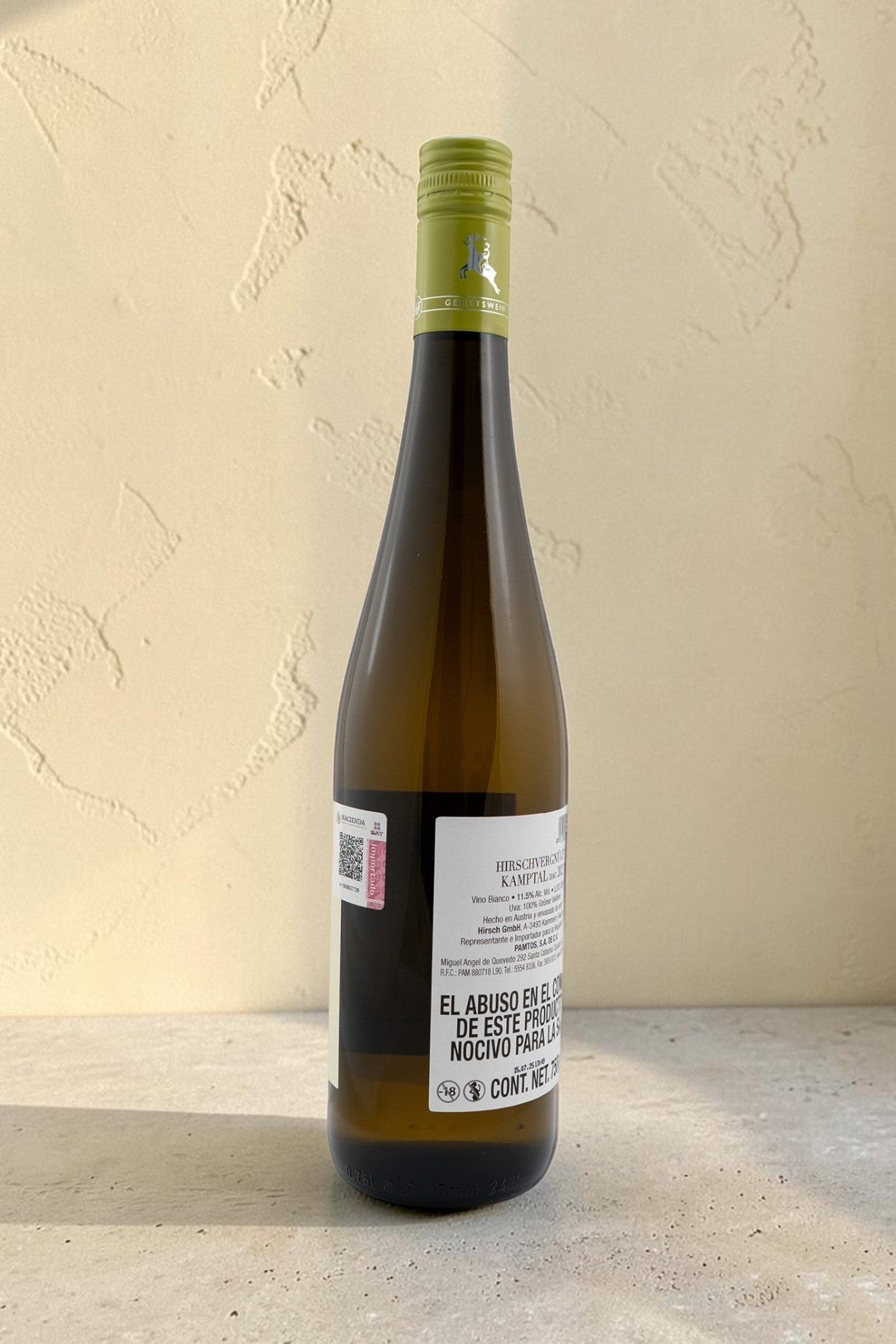 Botella de vino blanco Wellnex Hirsch VB Gruner Veltliner Kamptal con etiqueta informativa sobre fondo neutro