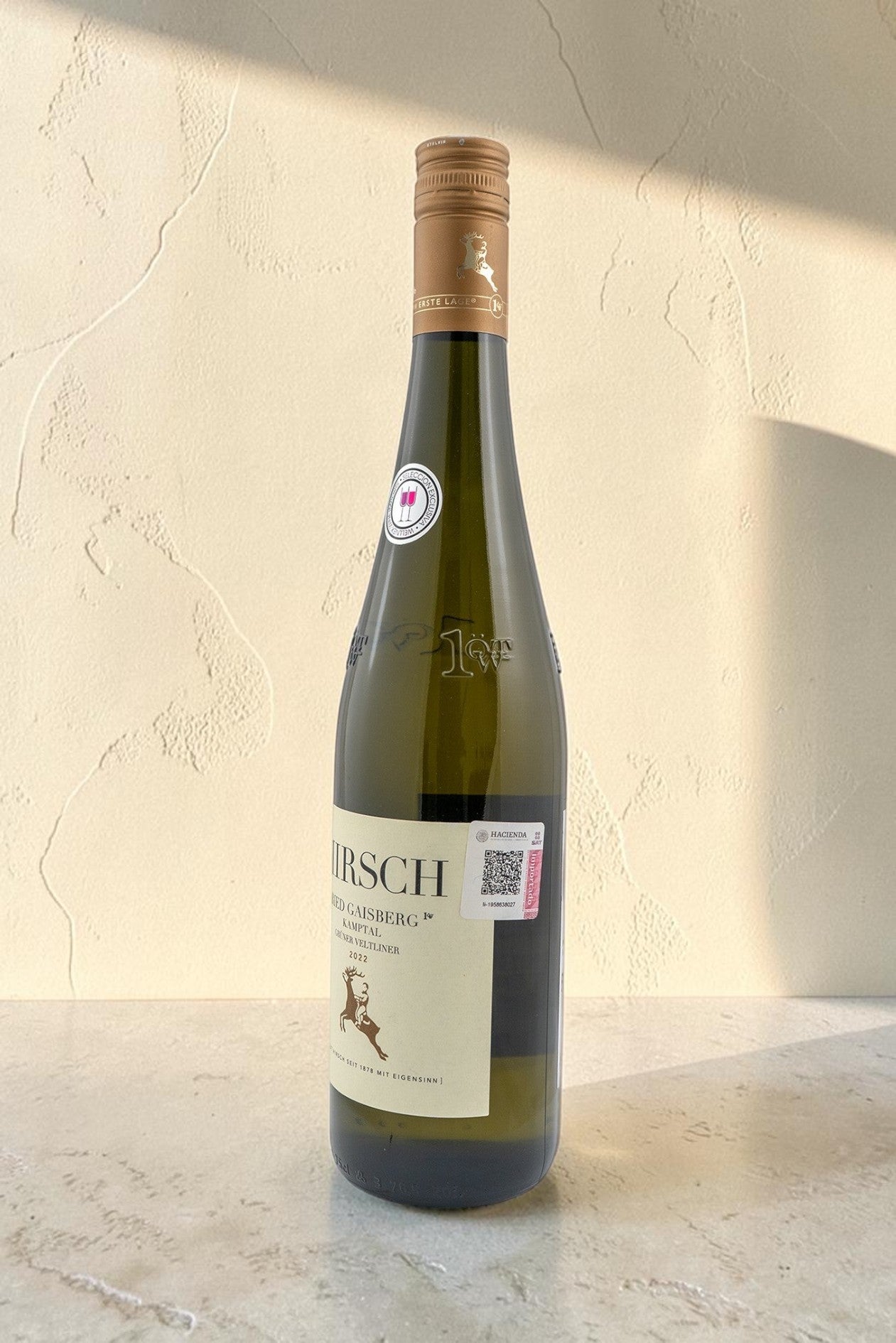 Botella de vino blanco Wellnex Hirsch VB Ried Gaisberg Gruner Veltliner con etiqueta elegante sobre fondo neutro