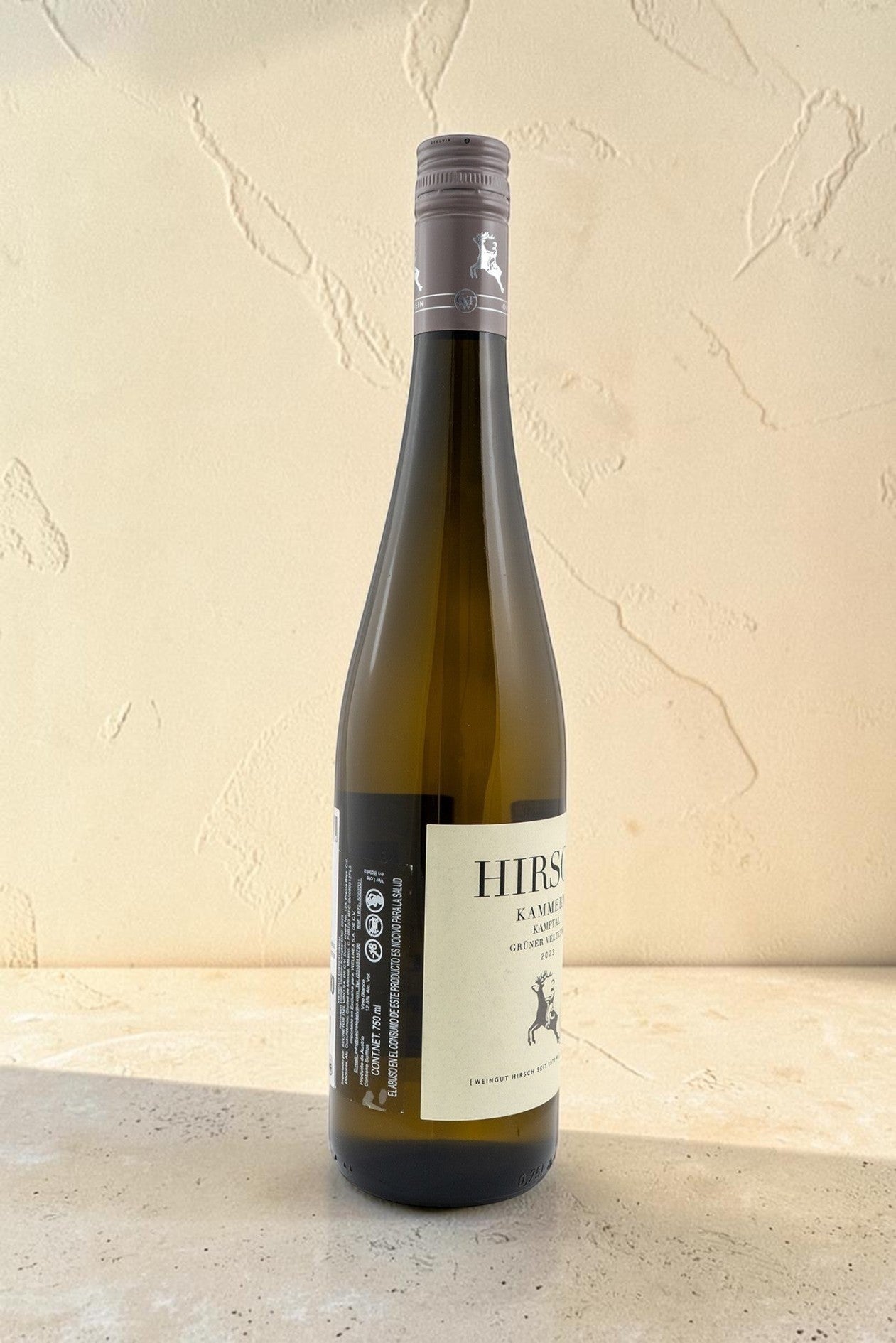 Botella de vino blanco Hirsch VB Kammern Gruner Veltliner Kamptal de Wellnex sobre superficie clara