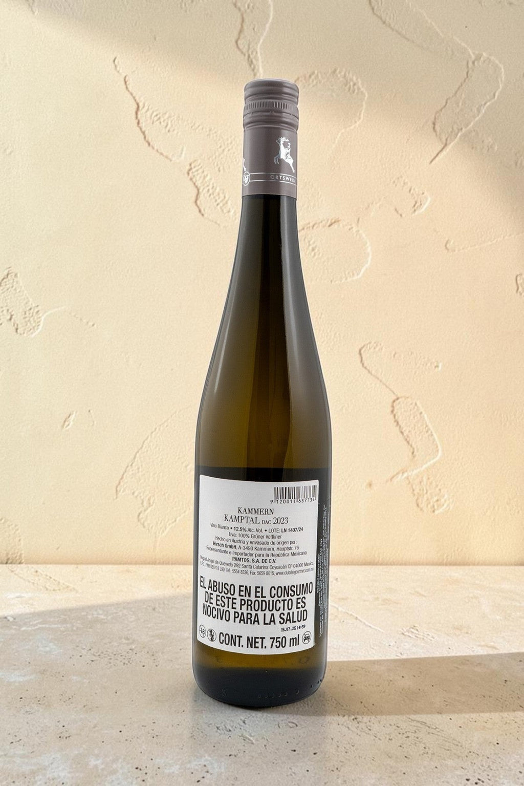 Botella de vino blanco Hirsch VB Kammern Gruner Veltliner de Wellnex sobre superficie clara con luz natural