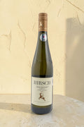Botella de vino blanco Hirsch VB Ried Renner Kampler Gruner Veltliner 2022 de Wellnex sobre superficie clara
