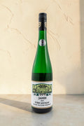 Botella de vino blanco Wellnex Jamek Stein AM Rain Gruner Veltliner Federspiel sobre superficie de piedra clara
