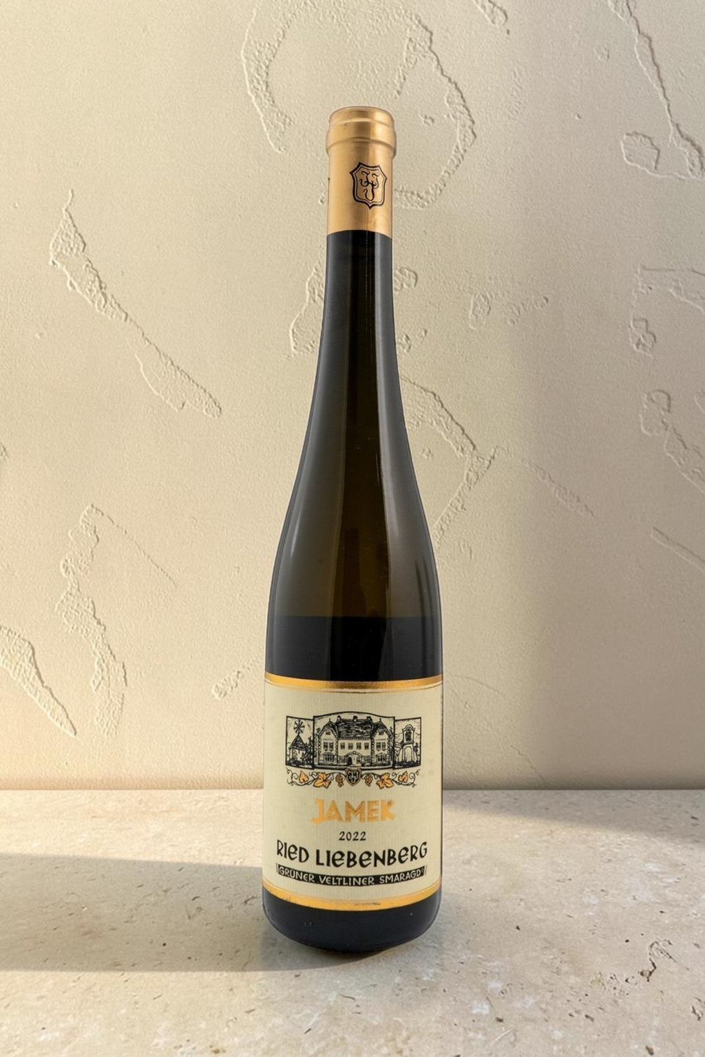 Botella de vino blanco Wellnex Jamek Ried Liebenberg Gruner Veltliner Smaragd con etiqueta clásica sobre fondo claro