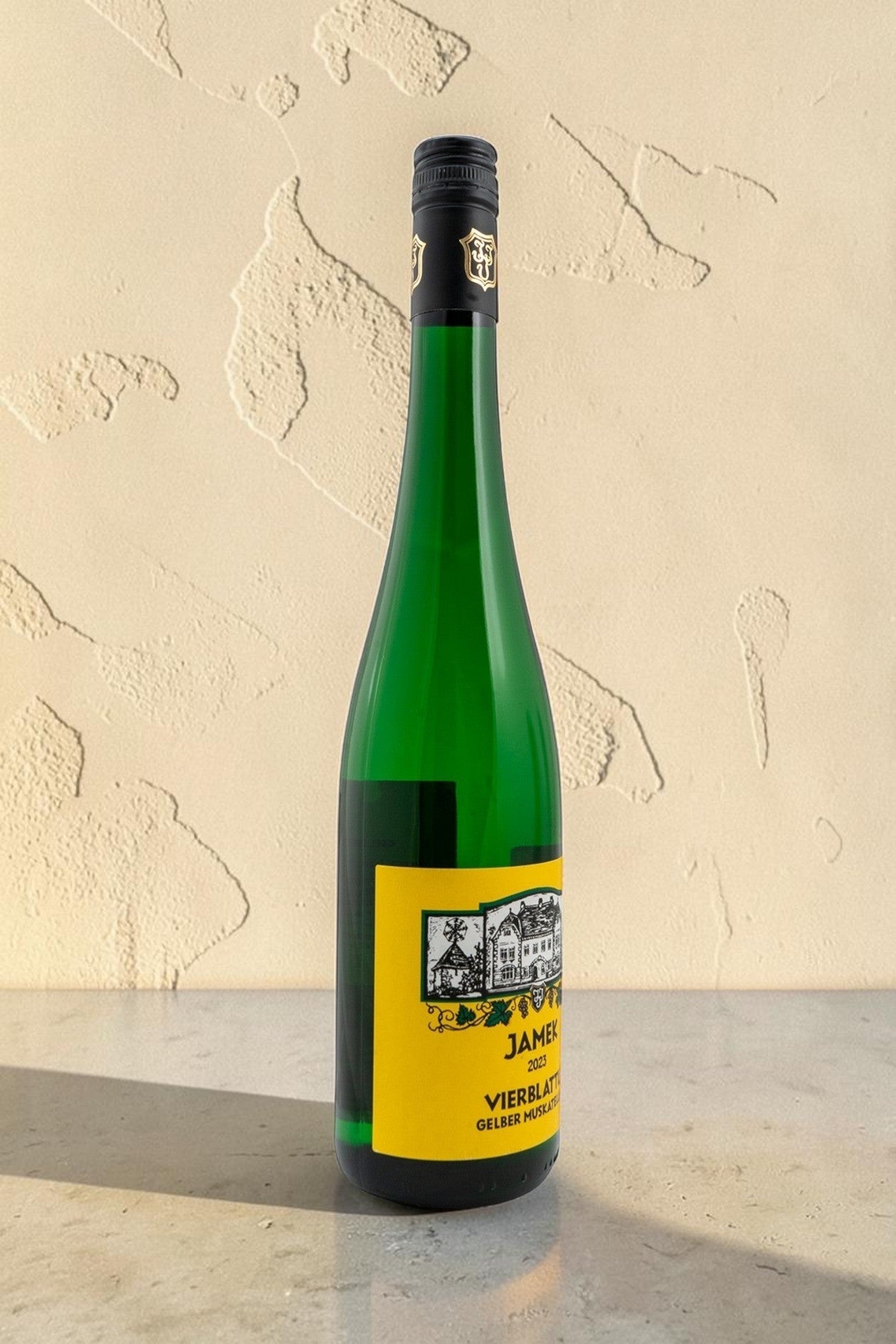 Botella de vino blanco Wellnex Jamek Vierblattl Gelber Muskateller 2023 con etiqueta amarilla sobre fondo claro
