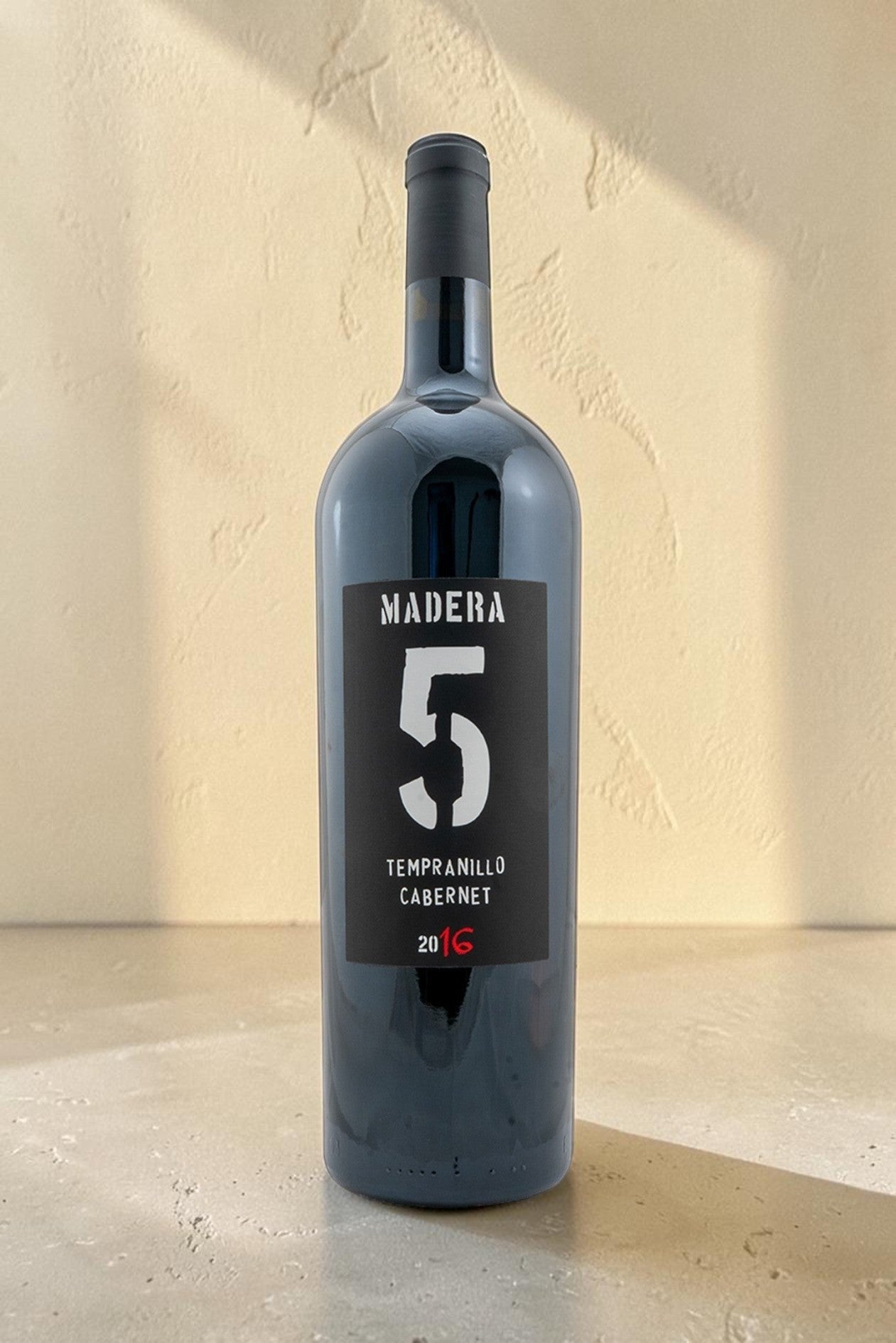 Botella de vino tinto Magnum Tempranillo Cabernet de Wellnex con etiqueta negra y numero cinco grande