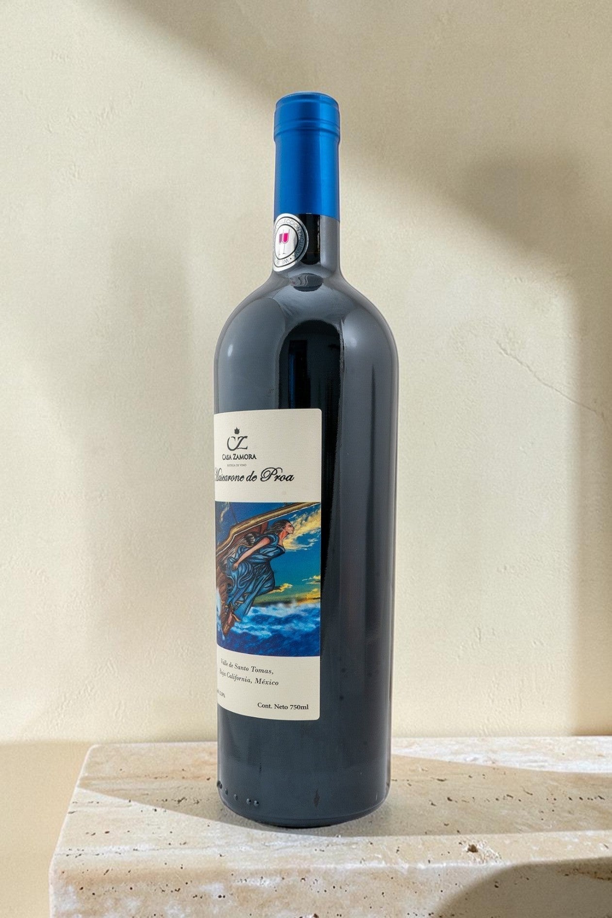 Botella de vino tinto Wellnex Mascarone de Proa con etiqueta ilustrada sobre base de piedra clara
