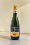 Botella de cava Wellnex Mestres Clos Damiana 2015 con etiqueta artística sobre superficie clara