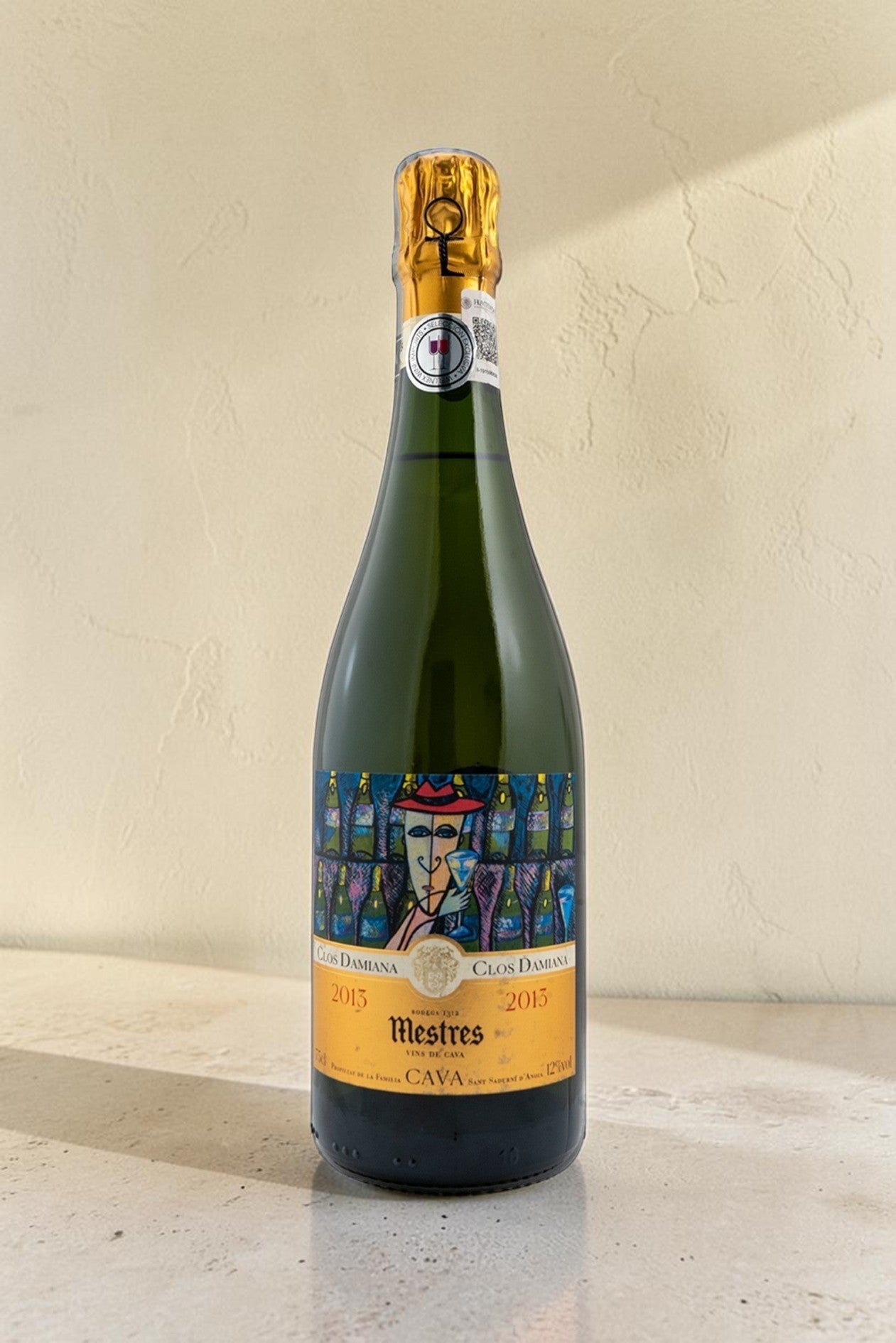 Botella de cava Wellnex Mestres Clos Damiana 2015 con etiqueta artística sobre superficie clara