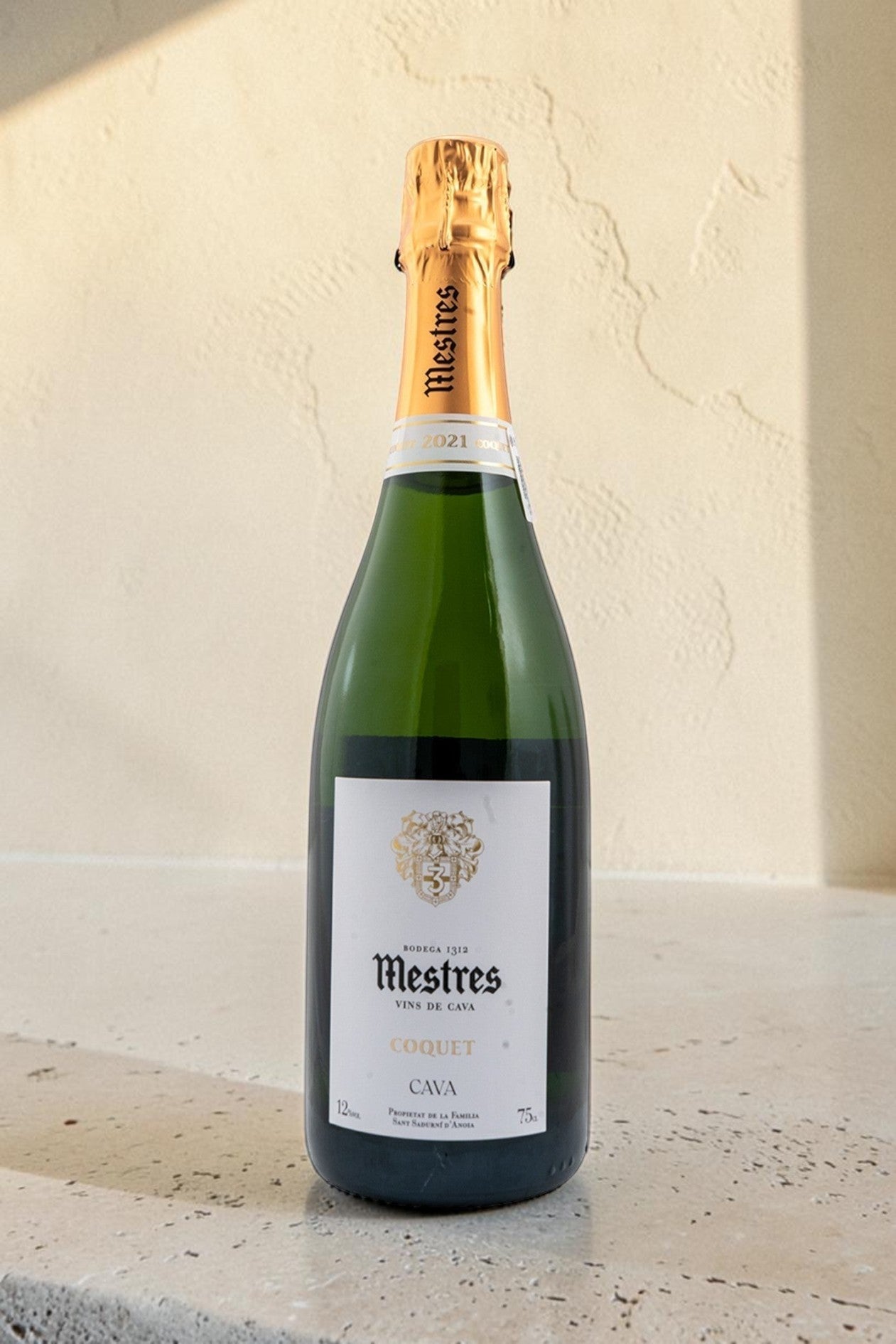 Botella de cava Wellnex Mestres Coquet con etiqueta elegante y cápsula dorada sobre fondo neutro