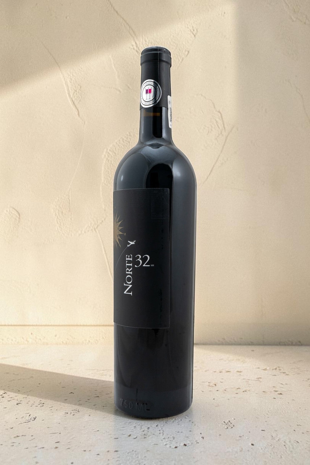 Botella de vino tinto Wellnex Norte 32 Etiqueta Negra con etiqueta elegante sobre fondo neutro