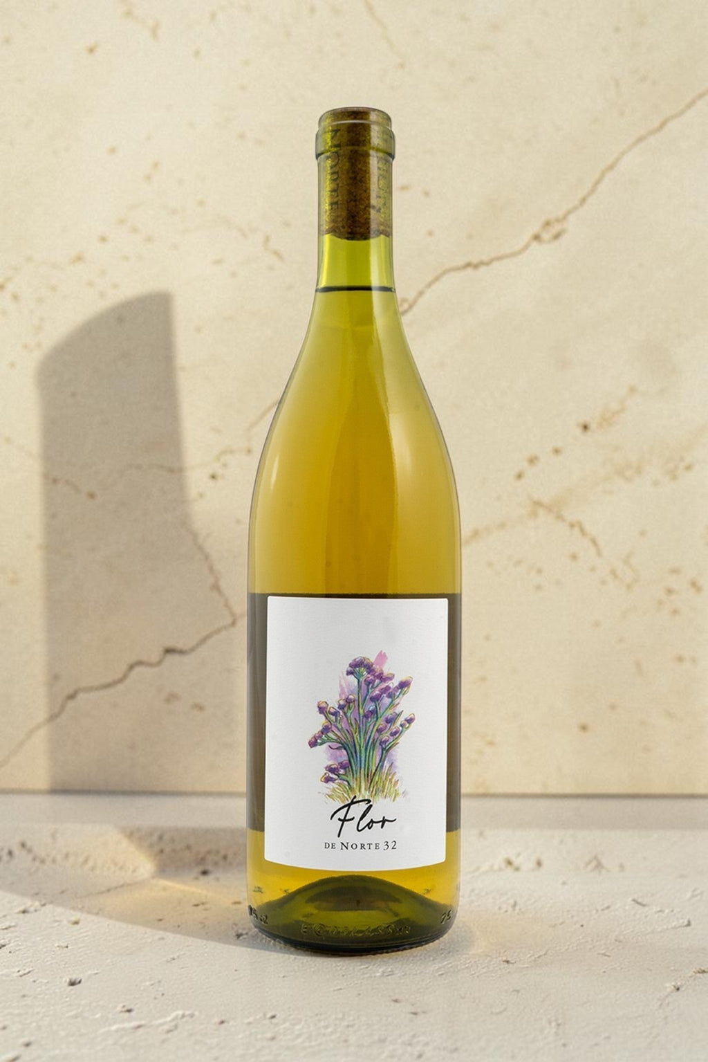 Botella de vino blanco Wellnex Norte 32 Flor con etiqueta ilustrada de flores sobre fondo de piedra beige.