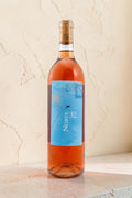 Botella de vino rosado Wellnex Norte 32 Etiqueta Azul con tonos asalmonados y etiqueta elegante sobre fondo neutro