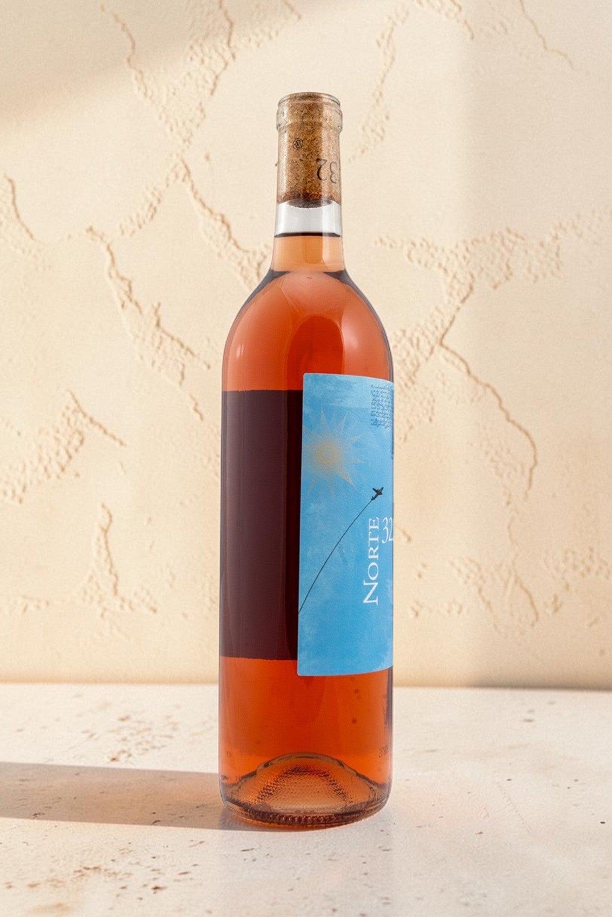 Botella de vino rosado Wellnex Norte 32 Etiqueta Azul con tono asalmonado brillante y etiqueta distintiva