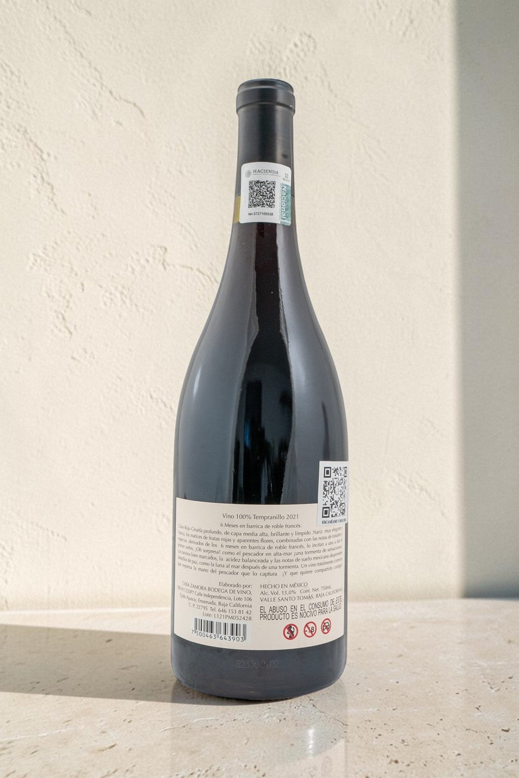 Botella de vino tinto Pescador de Wellnex con etiqueta trasera detallada sobre fondo neutro