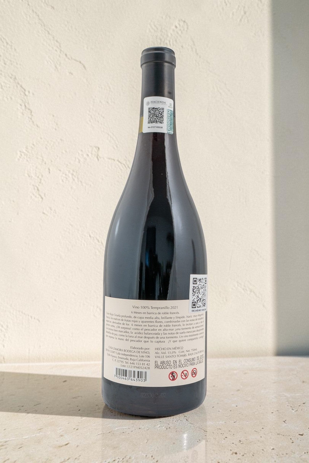 Botella de vino tinto Pescador de Wellnex con etiqueta trasera detallada sobre fondo neutro