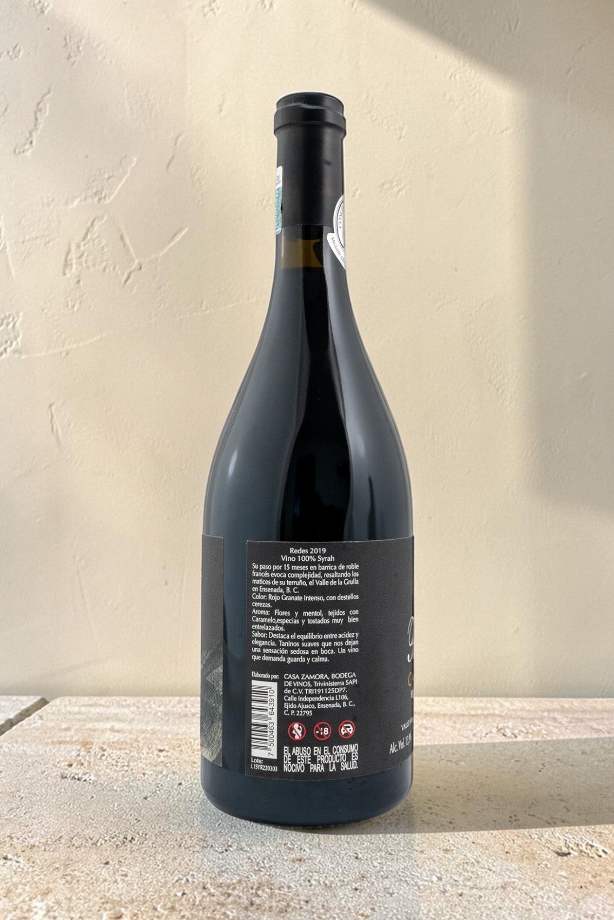 Botella de vino tinto Redes de Wellnex con etiqueta informativa detallando notas de cata y origen en Ensenada