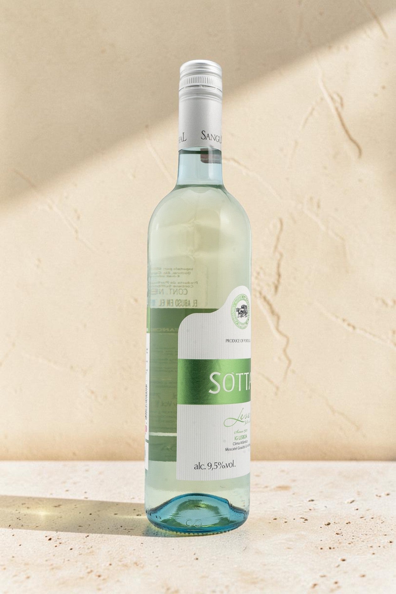 Botella de vino blanco Sanguinhal Sottal de Wellnex con etiquetas verdes sobre fondo de piedra beige