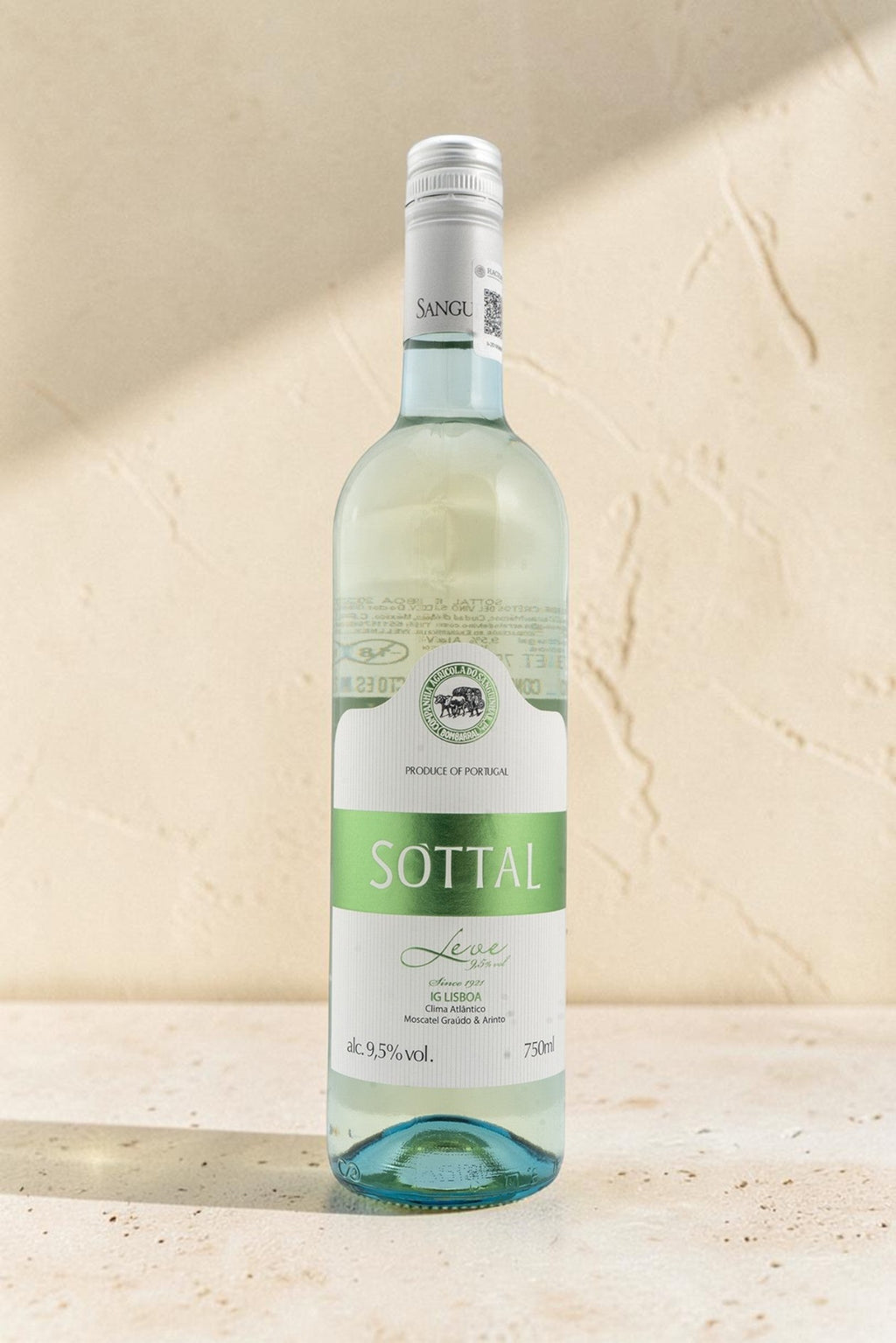 Botella de vino blanco Sanguinhal Sottal de Wellnex con etiqueta verde y blanca sobre fondo de piedra texturizada