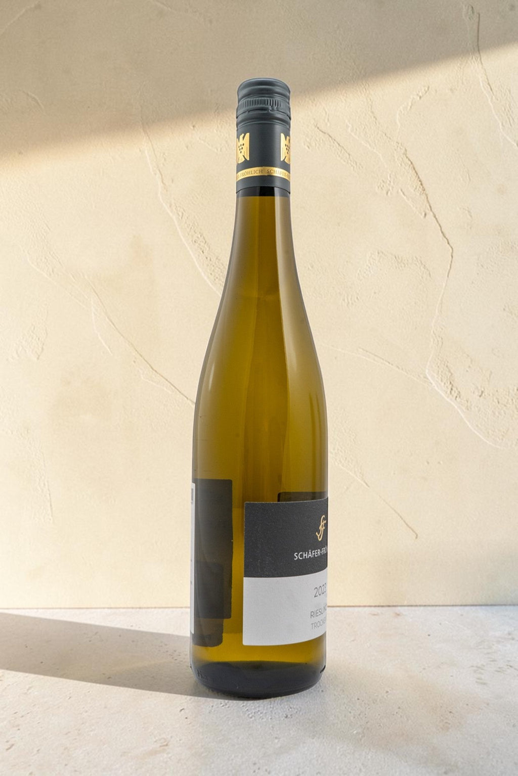 Botella de vino blanco Schafer Frohlic VB Riesling Trocken con etiqueta elegante sobre fondo neutro