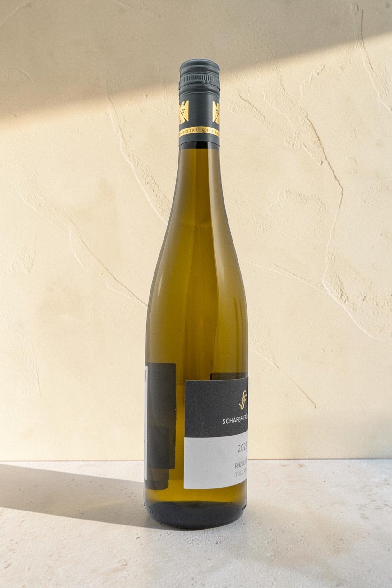 Botella de vino blanco Schafer Frohlic VB Riesling Trocken con etiqueta elegante sobre fondo neutro