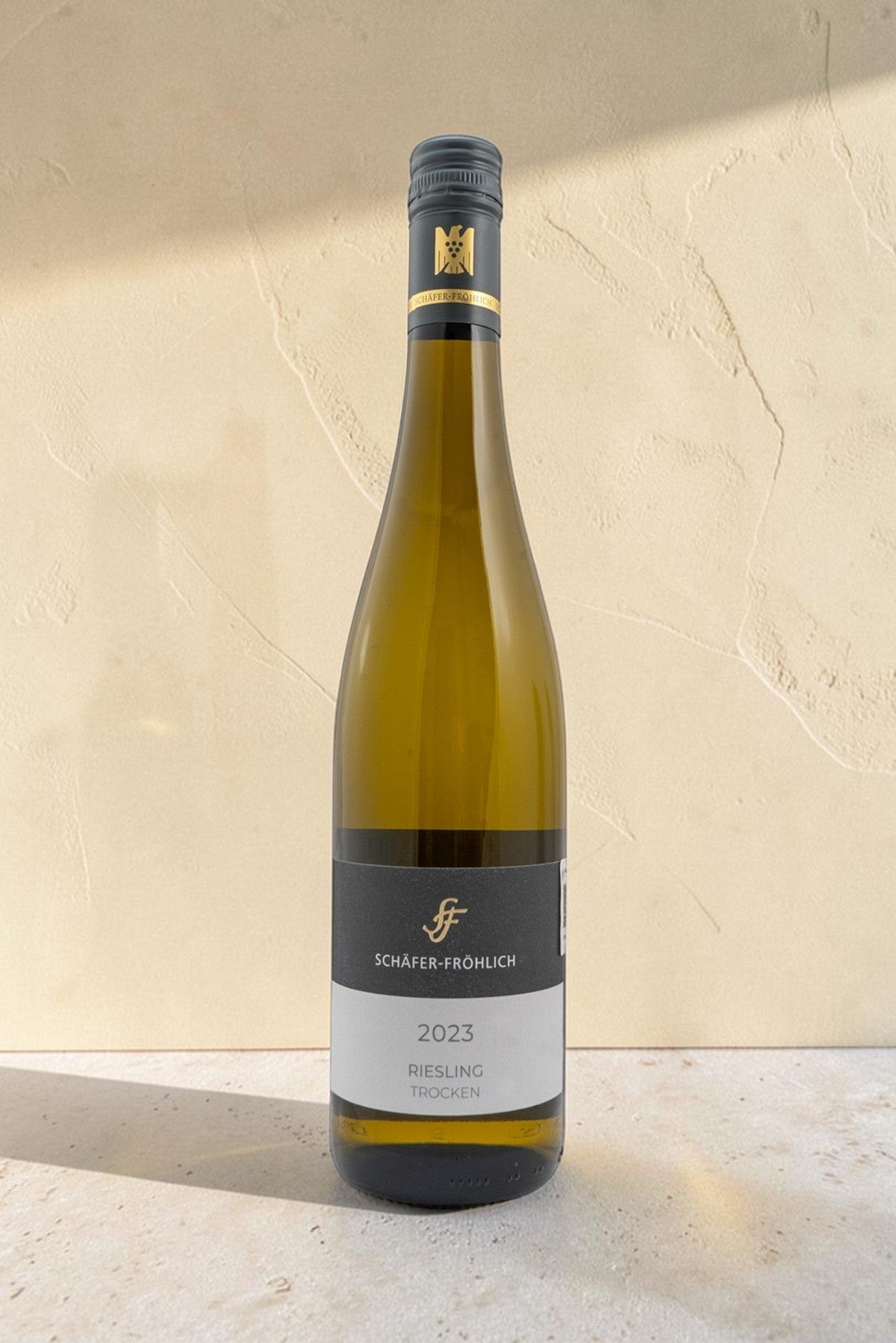 Botella de vino blanco Wellnex Schafer Frohlich Riesling Trocken 2023 sobre fondo neutro con etiqueta elegante