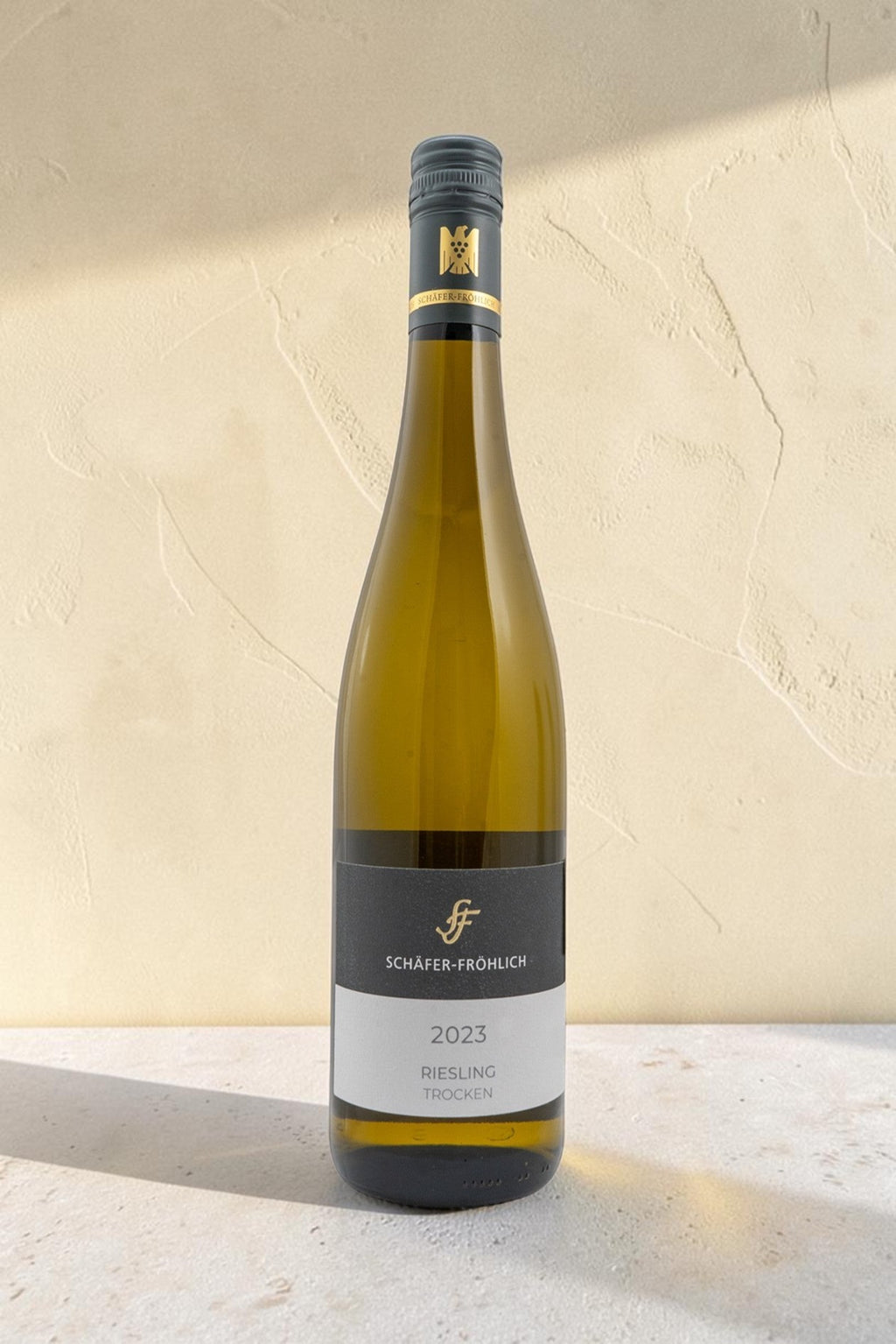 Botella de vino blanco Wellnex Schafer Frohlich Riesling Trocken 2023 sobre fondo neutro con iluminación suave