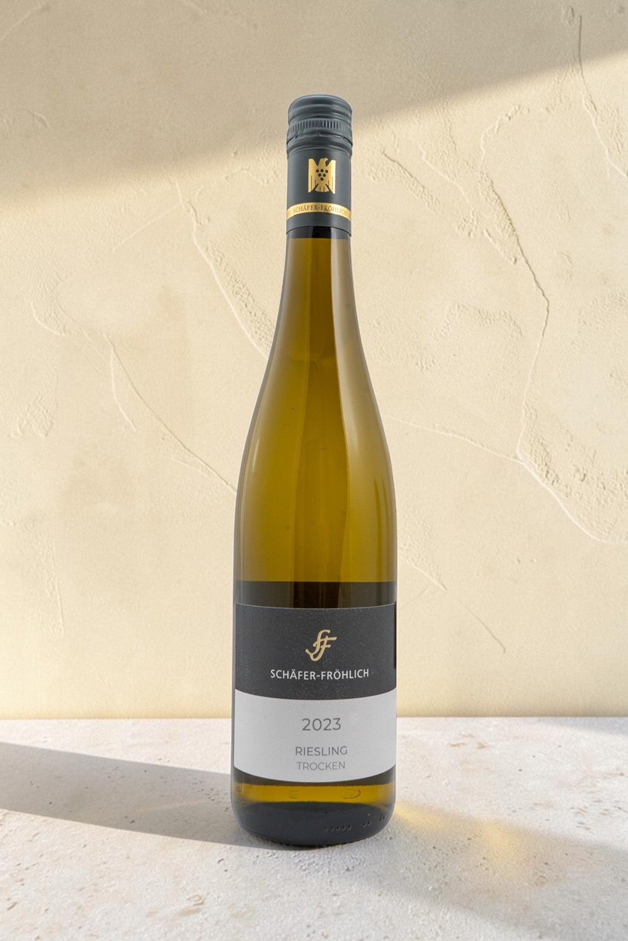 Botella de vino blanco Wellnex Schafer Frohlich Riesling Trocken 2023 sobre fondo neutro con iluminación suave