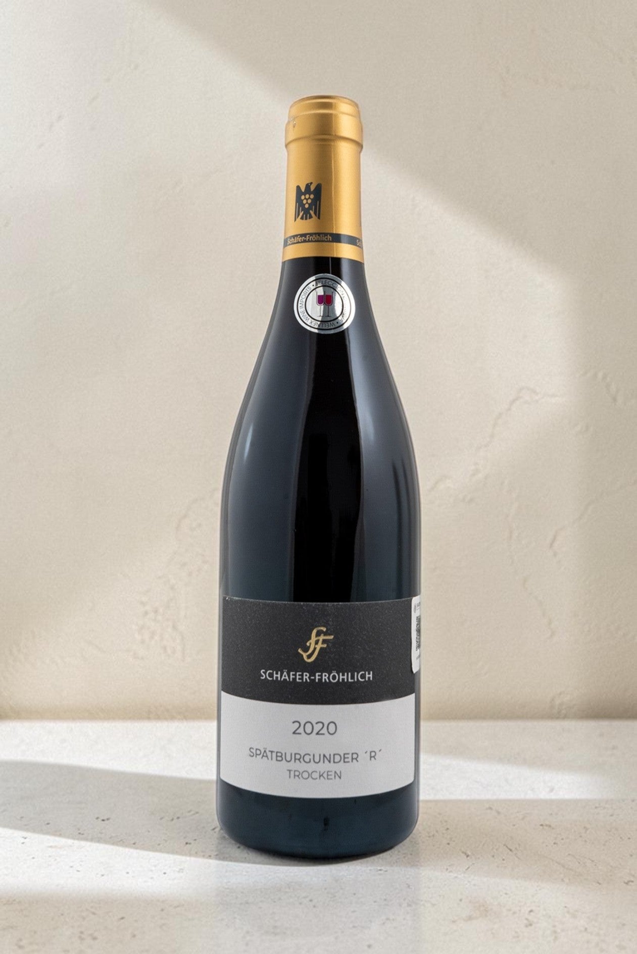 Botella de vino tinto Wellnex Schafer Frohlich Spatburgunder R Trocken 2020 con etiqueta elegante sobre fondo neutro