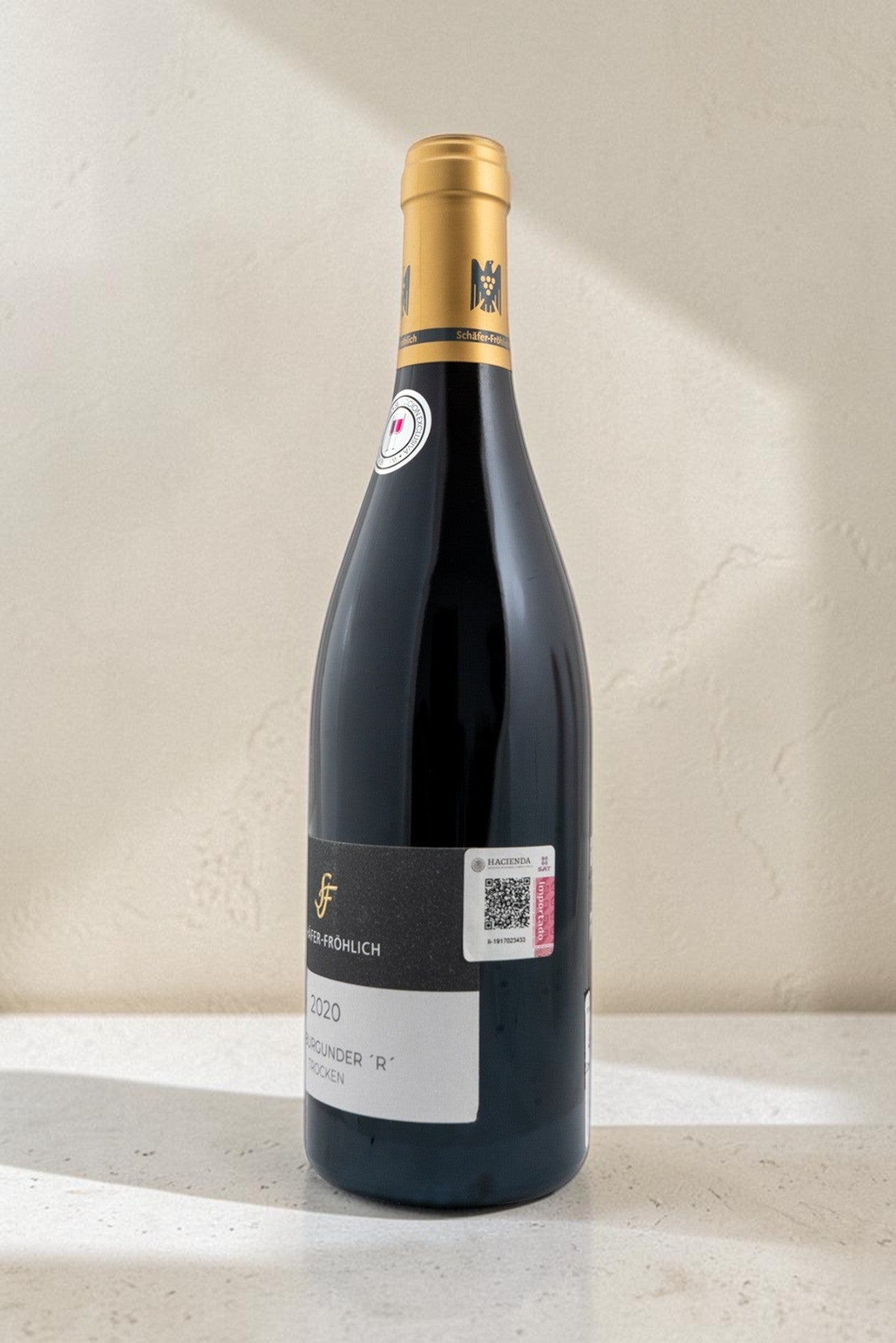Botella de vino tinto Wellnex Schafer Frohlich Spatburgunder R Trocken con etiqueta elegante sobre fondo neutro