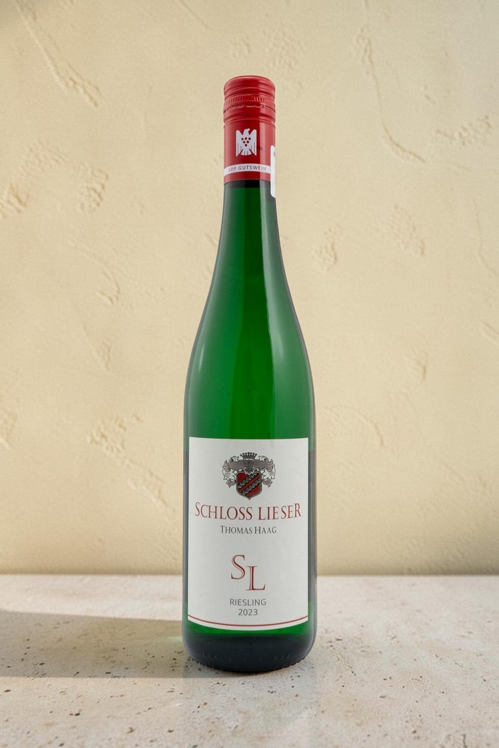 Botella de vino blanco Wellnex Schloss Lieser SL Riesling 2023 con etiqueta elegante sobre fondo neutro