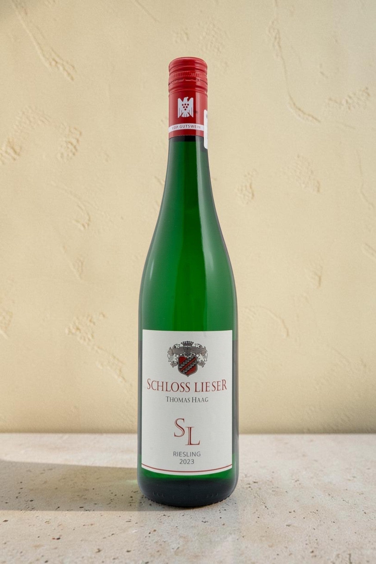 Botella de vino blanco Wellnex Schloss Lieser SL Riesling 2023 con etiqueta elegante sobre fondo neutro