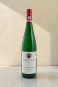 Botella de vino blanco Riesling Kabinett Schloss Lieser Wehlener Sonnenuhr de Wellnex sobre superficie clara