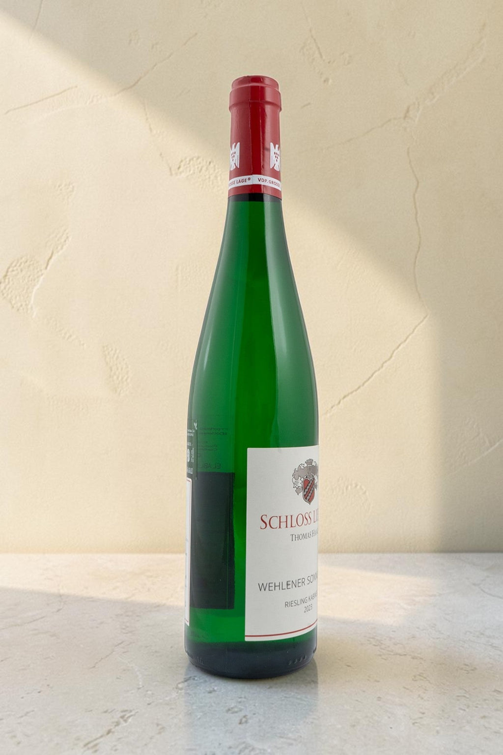 Botella de vino blanco Wellnex Schloss Lieser Riesling Kabinett con etiqueta clásica sobre fondo neutro